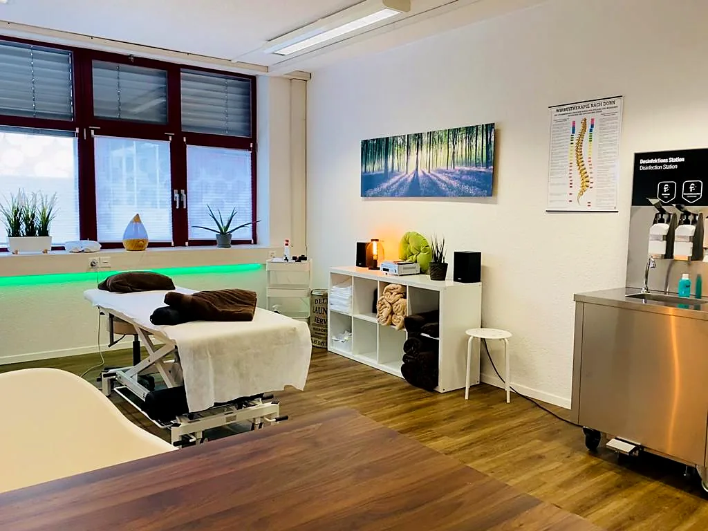 Behandlungsraum mit Massageliege, Fenster und Regal